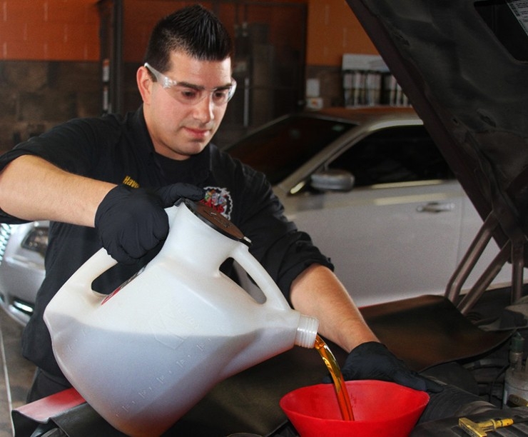 Havoline pro pouring oil into vehicle